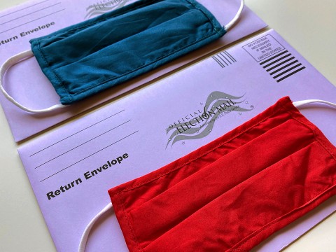 photograph of two election mail envelopes with face masks