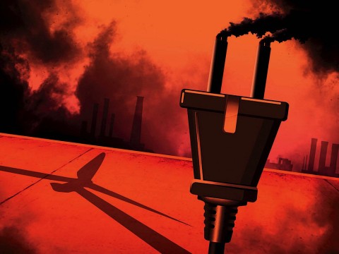 A smokestack spewing smoke with a wind turbine in its shadow