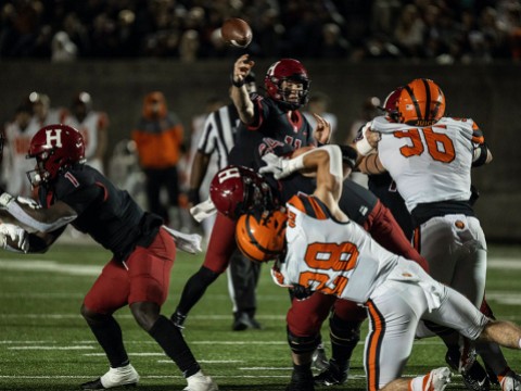 Harvard quarterback Charlie Dean gets off a pass despite Princeton rush.