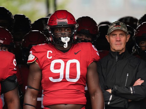 Senior defensive lineman David Madzivanyika, captain and defensive lineman Truman Jones, and coach Tim Murphy get ready to lead the team out of the tunnel before kickoff.