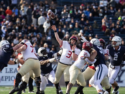Luke Emge throws the football amidst Yale defenderss