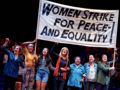 Scene from "Gloria, A Life," showing women marching in solidarity with protest sign