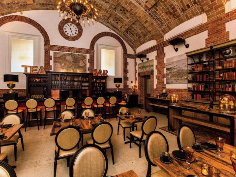 Cozy Map Room Tea Lounge with books, bar, and vaulted ceiling