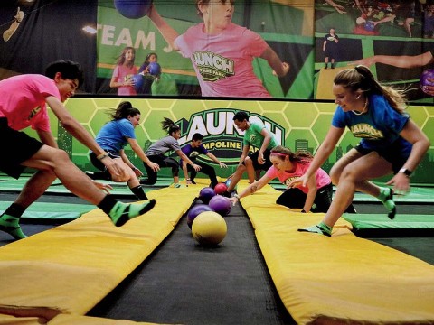 People playing dodgeball on indoor trampolines 