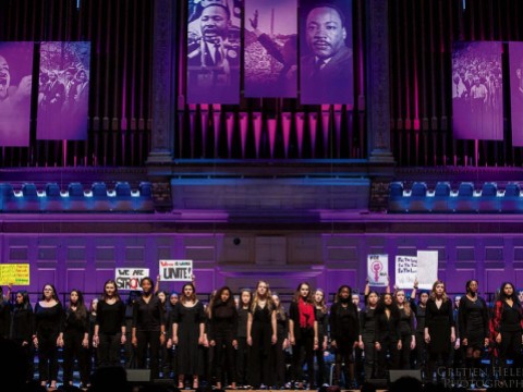 Children singers performing on stage with purple lighting 