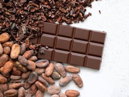 a bar of chocolate next to a pile of cacao beans