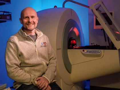 Matthias Nahrendorf seated in front of a PET/CT scanner