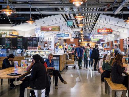 An indoor photo of people eating and shopping at Boston Public Market