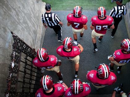 Photo of Harvard football players heading onto the field