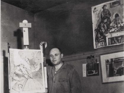 Photograph of artist Romare Bearden standing by an easel c. 1940