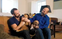 Sullivan (right)  at home with his husband, actor Aaron Tone, and their  two beagles