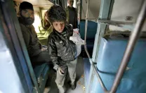 At the train station in Jaipur, India, collecting empty water bottles fetches about 100 rupees ($2) a day. Here, eight-year-old Badal searches inside a train car.