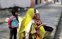 Families make their homes on a sidewalk adjacent to the train station, and survive by begging.