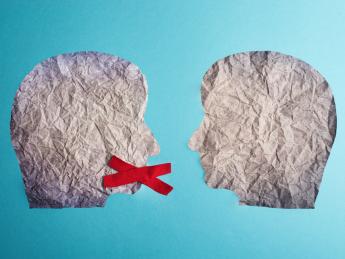 Two heads made of paper with red x over mouth of one head