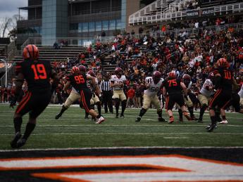 Harvard quarterback has the ball as Princeton players are in pursuit