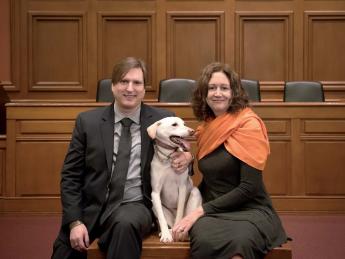 Chris Green and Kristen Stilt in Austin Hall’s Ames courtroom with Lola, Stilt’s rescue dog from Egypt