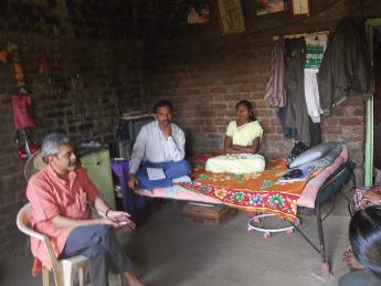 Photograph of Vikram Patel visiting with family members of a farmer in Maharashtra, India, who committed suicide