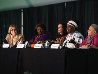 Moderator Jacqueline Bhabha seated at a table with panelists Agnes Binagwaho, Abby Maxman, Natalia Kanem, and Reema Nanavaty.