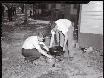 Forensic pioneer Joseph T. Walker (at left) collects blood and scraps of flesh from the bathtub drain of a 1936 murder victim.