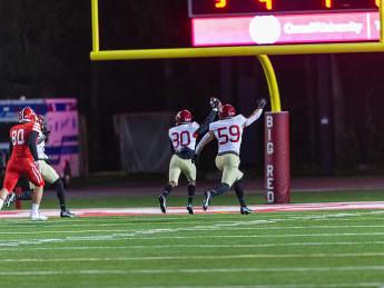 Senior Kobe Joseph, who broke in and blocked a Cornell punt,accompanies junior Jelani Machen as he holds the ball aloft and runs into the end zone to give Harvard a second-quarter lead.