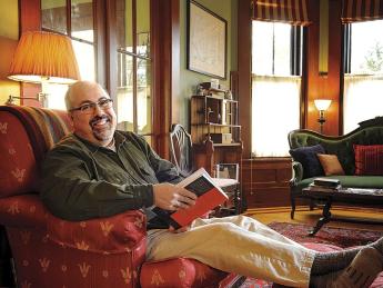 Poet and physician Rafael Campo relaxes at home with a book. 