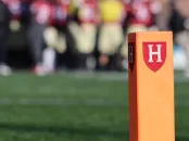 orange post on a football field with the Harvard Athletics shield