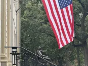 John Harvard statue and the American flag above