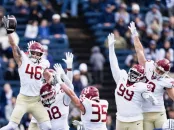 Football players in white and maroon uniforms celebrating a play on the field.