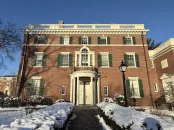 Loeb House surrounded by snow and greenery under a clear blue sky.