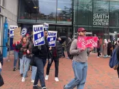 Picketers holding signs march outside the Smith Campus Center, advocating for labor rights.