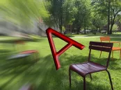 Red letter "A" overblurred lawn with colorful chairs in the background.