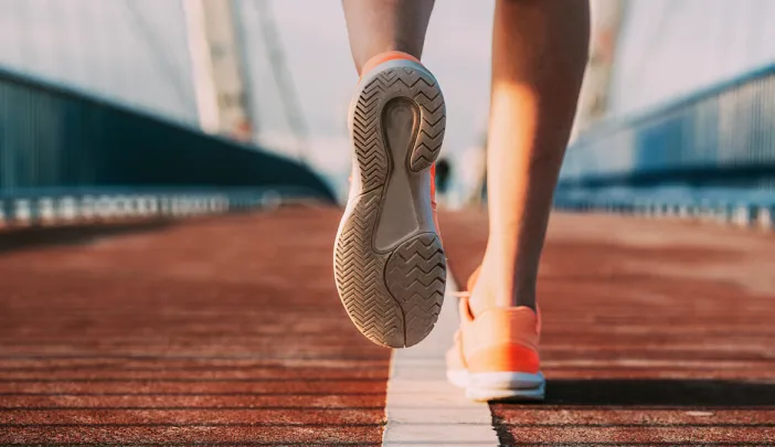 person's shoes while running on a bridge