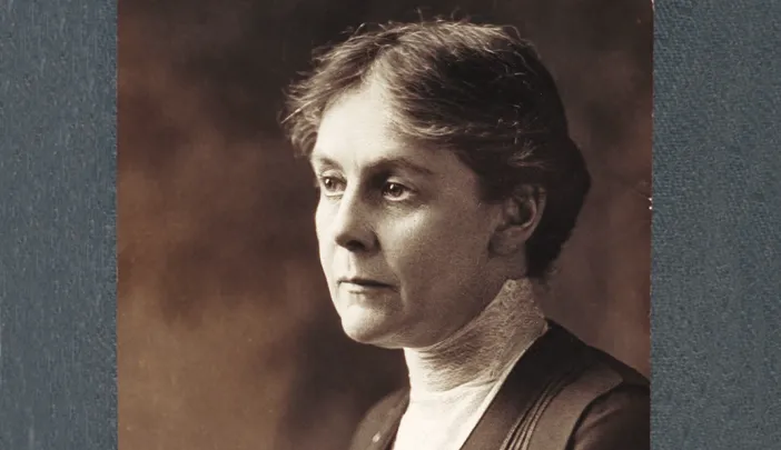 Alice Hamilton in a dark dress with high lace collar, gazing left in a sepia-toned portrait