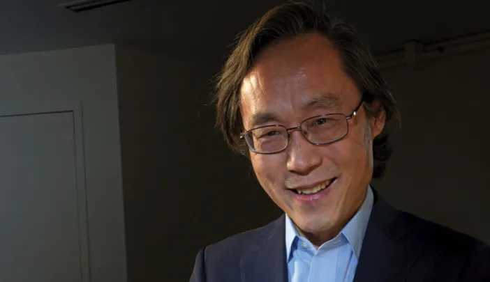 Frank Hu holds a plate filled with food. 