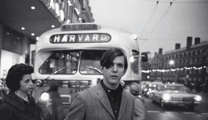 Gram Parsons stands in front of a bus in Harvard Square