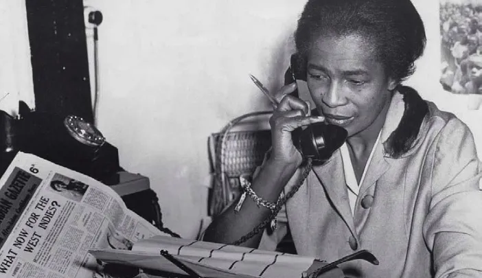 Black journalist Claudia Jones on the phone in the offices of the “West Indian Gazette” in London
