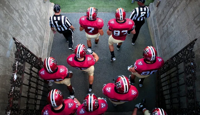 Photo of Harvard football players heading onto the field
