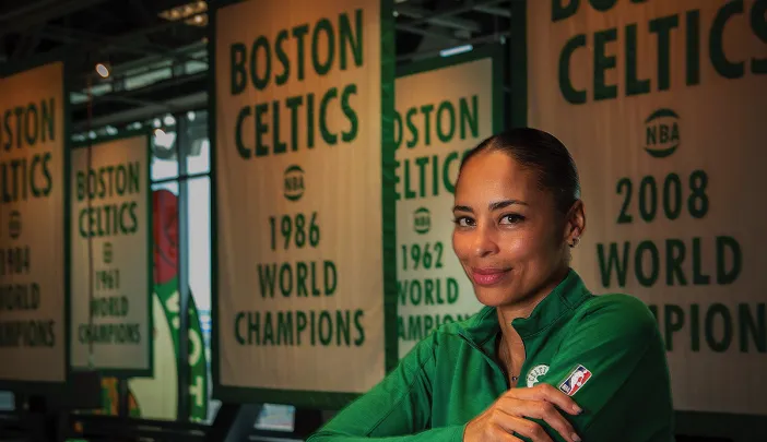 Allison Feaster wearing a green Celtics shirt in front of team championship banners