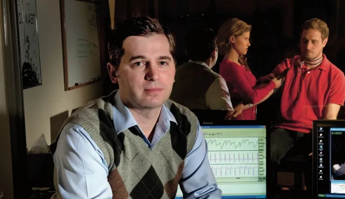 Matthew Nock sits in his lab’s control room, where researchers record subjects’ behavioral and physiological responses during experiments. For example, they might measure whether people who engage in self-injury show greater emotional distress, in response to frustrating tasks, than people who do not. (Nock’s lab manager and a postdoctoral fellow are seen in the adjoining room through one-way glass.)