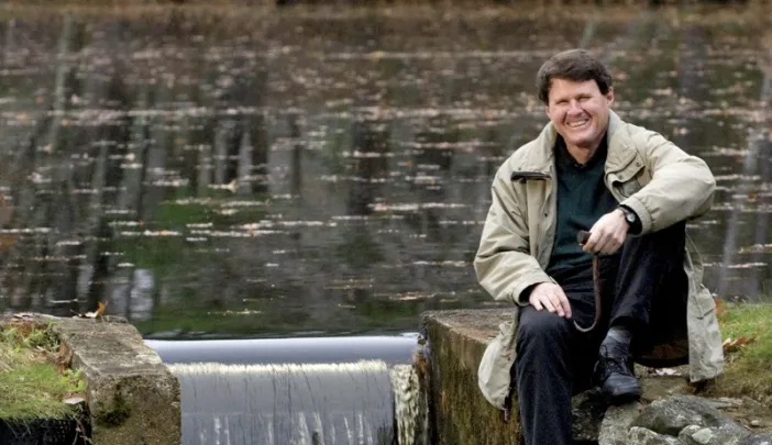 When not dealing with major global water issues, John Briscoe manages this small dam near his home. He holds the hook used to open the sluice gate.