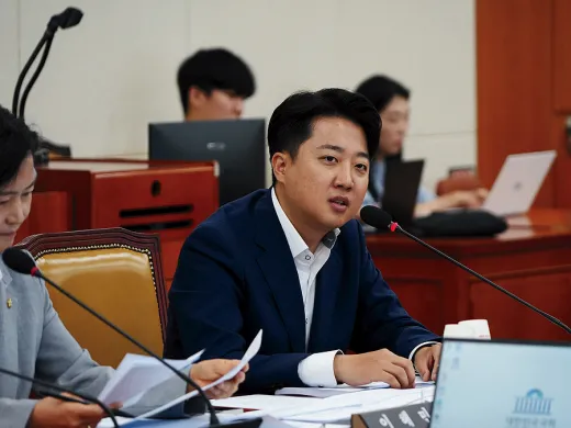 Lee Junseok, a South Korean politician, is seated at a desk in front of a microphone. 