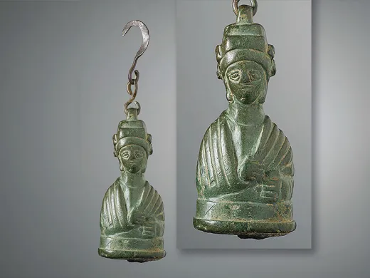 Bronze weight shaped as a bust of an empress, featuring intricate details and a hook for hanging.