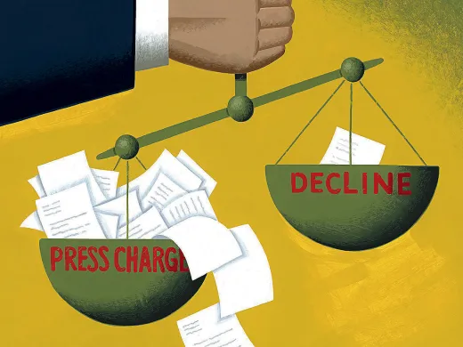 Illustration of a scale balancing papers labeled "Press Charges" against "Decline," held by a large hand.