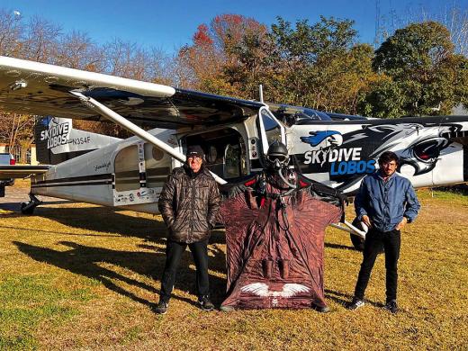 Alejandro Montagna standing in front of a small airplane wearing a wingsuit