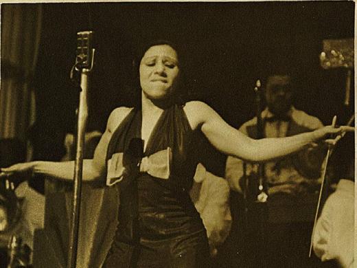 Blanche Calloway spreading her arms during a performance