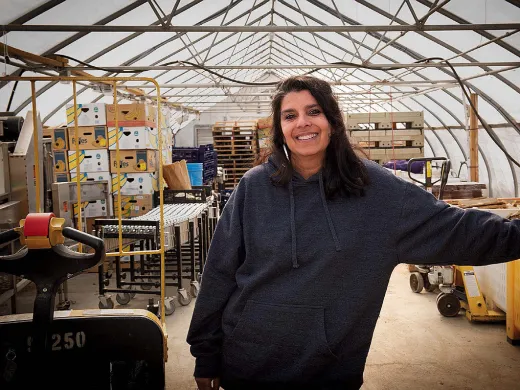Usha Thakrar standing in the greenhouse production center at Stonefield Farm