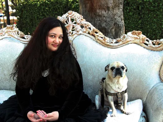 Author Gabrielle Zevin seated on a sofa in Los Angeles with her dog Nico