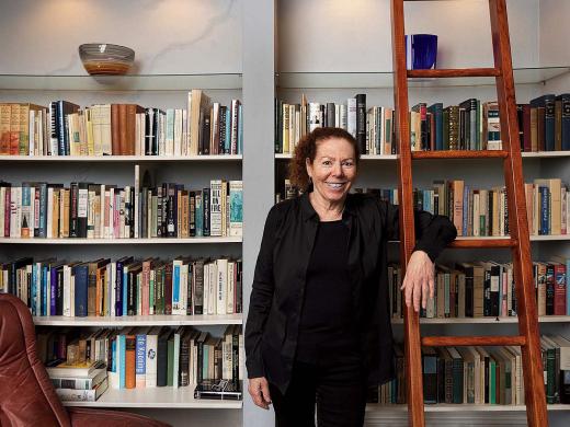 Wendy Lesser standing happily among her books 