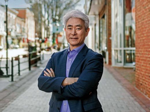 Portrait image of Walter Kim standing on a street with arms folded across his chest