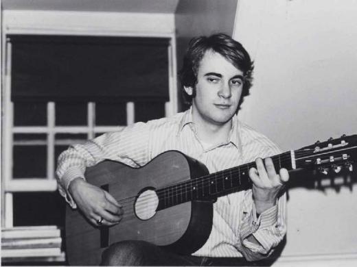 Photograph of William Randall playing guitar in his Lowell House room, c. 1970-1971